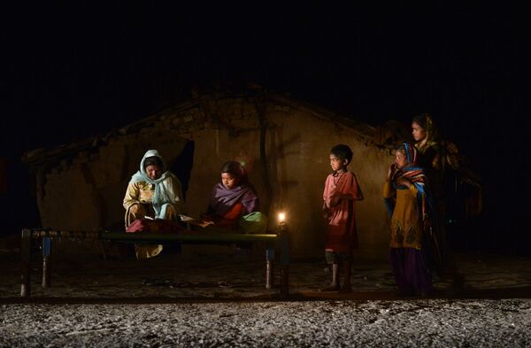 An Indian girl (C) studies by candle light in a slum area without electric power in Phillaur - Sputnik International