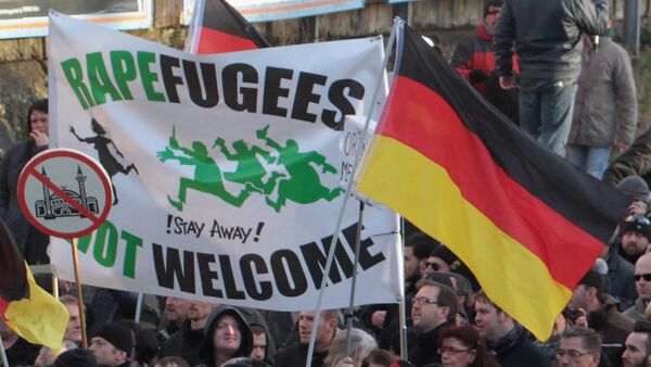 Right-wing demonstrators hold a sign Rapefugees not welcome - !Stay away! and a sign with a crossed out mosque as they march in Cologne, Germany - Sputnik International