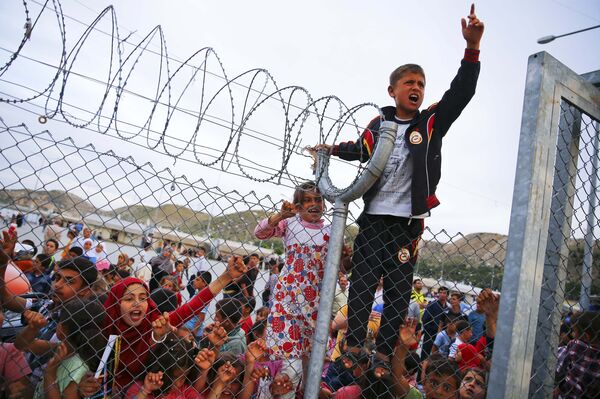 Refugee youths gesture from behind a fence at Nizip refugee camp near Gaziantep, Turkey, April 23, 2016.  - Sputnik International