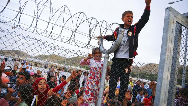 Refugee youths gesture from behind a fence at Nizip refugee camp near Gaziantep, Turkey, April 23, 2016. - Sputnik International