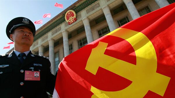A Chinese policeman holds a Chinese Communist Party flag - Sputnik International