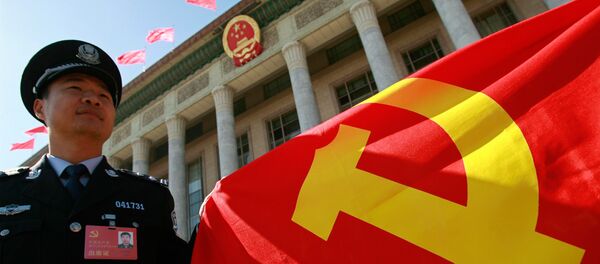 A Chinese policeman holds a Chinese Communist Party flag A Chinese policeman holds a Chinese Communist Party flag - Sputnik International