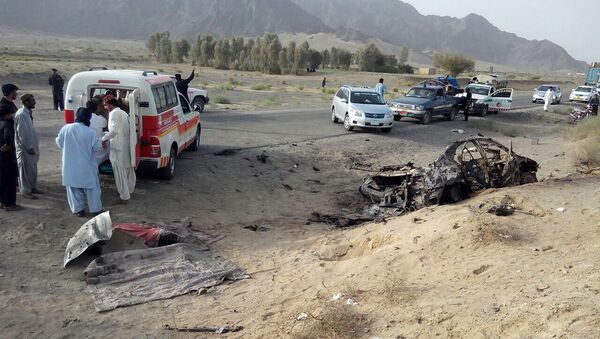 This photo taken by freelance photographer Abdul Malik on Saturday, May 21, 2016, purports to show volunteers standing near the wreckage of the destroyed vehicle, in which Mullah Mohammad Akhtar Mansour was allegedly traveling in the Ahmed Wal area in Baluchistan province of Pakistan, near Afghanistan border - Sputnik International