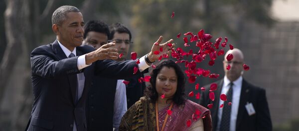 President Barack Obama throws rose petals as he participates in a wreath laying ceremony at the Raj Ghat Mahatma Gandhi Memorial, New Delhi, India, Sunday, Jan. 25, 2015 - Sputnik International