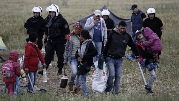 A migrant family carries their belongings during an evacuation operation by police forces of a makeshift migrant camp at the border at the Greek-Macedonian border near the village of Idomeni, on May 24, 2016 - Sputnik International