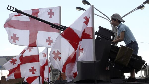 A Georgian boy plays atop an armored vehicle put on display with other Georgian military machinery to mark Independence Day in Tbilisi, Georgia, Saturday, May 26, 2012 - Sputnik International