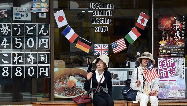 Elderly Japanese women sit under a welcome message outside a shop during the world leaders' visit to the Ise-Jingu Shrine in the city of Ise, Mie prefecture on May 26, 2016 on the first day of the G7 leaders summit - Sputnik International