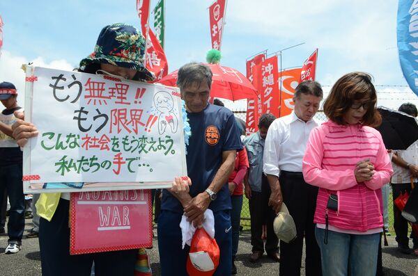 People offer a silent prayer in front of the US Kadena Air Base in Cyatan, Okinawa prefecture, to protest against the US military presence in Okinawa on May 21, 2016 - Sputnik International