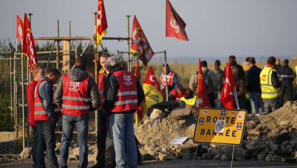 Striking French labour union employees stand near a barricade to block the entrance of the depot of the SFDM company near the oil refinery to protest the labour reforms law propal, in Donges, France, May 26, 2016. - Sputnik International