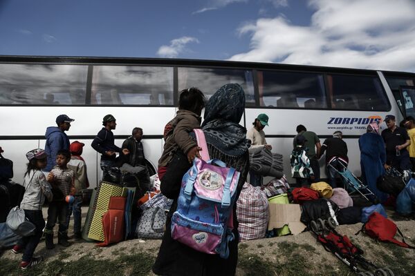 Refugees stand near a bus as they wait to be transferred to a hospitality centre during a police operation at a refugee camp at the border between Greece and Former Yugoslav Republic of Macedonia (FYROM), near the village of Idomeni, northern Greece,on May 25, 2016 Refugees stand near a bus as they wait to be transferred to a hospitality centre during a police operation at a refugee camp at the border between Greece and Former Yugoslav Republic of Macedonia (FYROM), near the village of Idomeni, northern Greece,on May 25, 2016 - Sputnik International