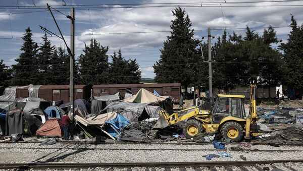 A bulldozer clears the debris at the site of the makeshift refugee and migrant camp in Idomeni close to the Greek-Macedonian border on May 25, 2016 - Sputnik International