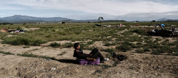 Syrian Kurd Nidal Daud, 37, sits on a suitcase as he waits to be transferred to a hospitality centre during a police operation at a refugee camp at the border between Greece and Macedonia, near the village of Idomeni, Greece, May 25, 2016 Syrian Kurd Nidal Daud, 37, sits on a suitcase as he waits to be transferred to a hospitality centre during a police operation at a refugee camp at the border between Greece and Macedonia, near the village of Idomeni, Greece, May 25, 2016 - Sputnik International