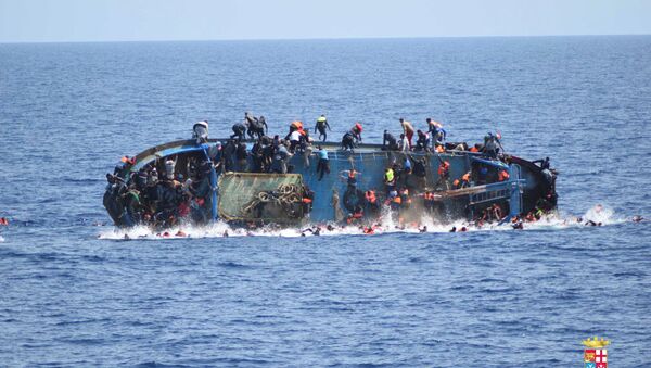 Migrants are seen on a capsizing boat before a rescue operation by Italian navy ships Bettica and Bergamini off the coast of Libya in this handout picture released by the Italian Marina Militare on May 25, 2016 - Sputnik International