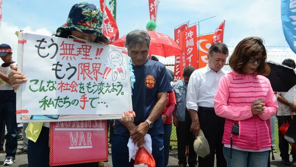 People offer a silent prayer in front of the US Kadena Air Base in Cyatan, Okinawa prefecture, to protest against the US military presence in Okinawa on May 21, 2016 - Sputnik International