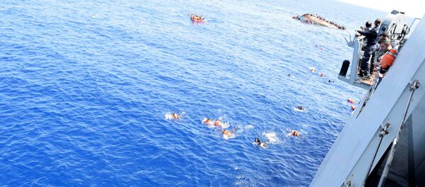 Migrants from a capsized boat are rescued during a rescue operation by Italian navy ships Bettica and Bergamini off the coast of Libya in this handout picture released by the Italian Marina Militare on May 25, 2016 - Sputnik International