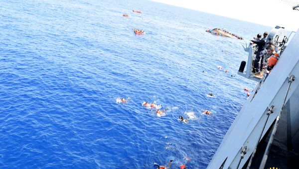 Migrants from a capsized boat are rescued during a rescue operation by Italian navy ships Bettica and Bergamini off the coast of Libya in this handout picture released by the Italian Marina Militare on May 25, 2016 - Sputnik International