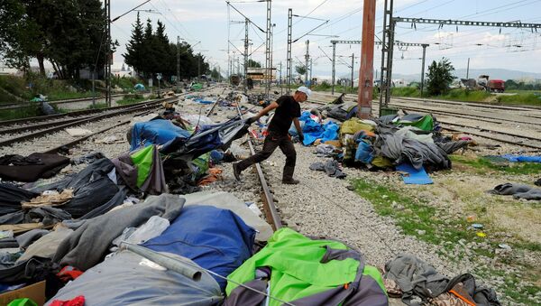 A worker removes tents used by migrants during a police operation to evacuate a migrants' makeshift camp at the Greek-Macedonian border near the village of Idomeni, Greece, May 26, 2016 - Sputnik International