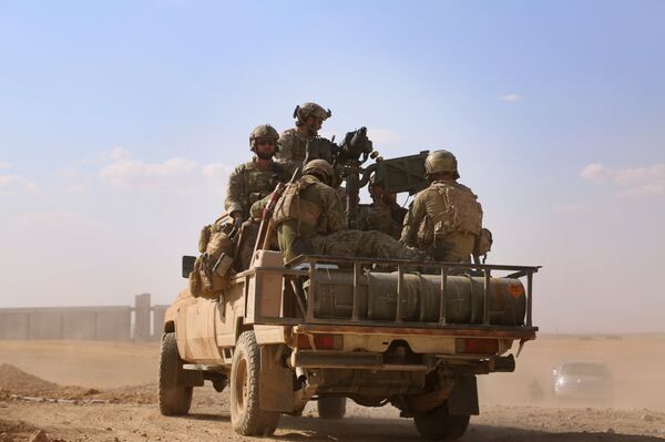 Armed men in uniform identified by Syrian Democratic forces as US special operations forces ride in the back of a pickup truck in the village of Fatisah in the northern Syrian province of Raqa on May 25, 2016 - Sputnik International