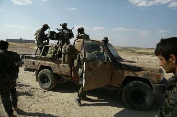 Armed men in uniforms identified by Syrian Democratic forces as US special operations forces stand in the back of a pickup truck in the village of Fatisah in the northern Syrian province of Raqa on May 25, 2016 - Sputnik International