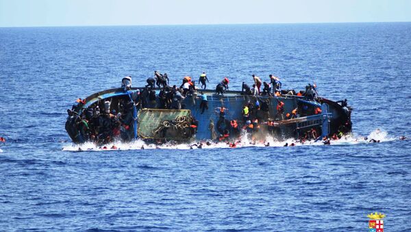 Migrants are seen on a capsizing boat before a rescue operation by Italian navy ships Bettica and Bergamini off the coast of Libya in this handout picture released by the Italian Marina Militare on May 25, 2016. - Sputnik International