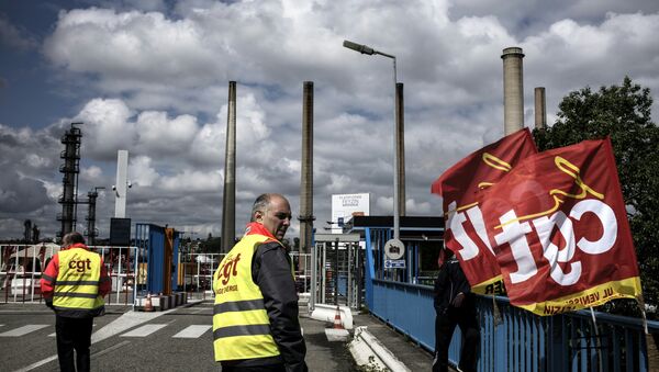 A worker stands next to French CGT union flags in front of the Total oil refinery of Feyzin, near Lyon, central-eastern France, on May 24, 2016, during a strike at the plant to protest against government labour reforms - Sputnik International