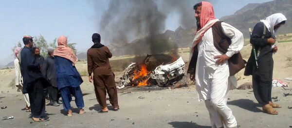 This photograph taken on May 21, 2016 shows Pakistani local residents gathering around a destroyed vehicle hit by a drone strike in which Afghan Taliban Chief Mullah Akhtar Mansour was believed to be travelling in the remote town of Ahmad Wal in Balochistan, around 160 kilometres west of Quetta. - Sputnik International