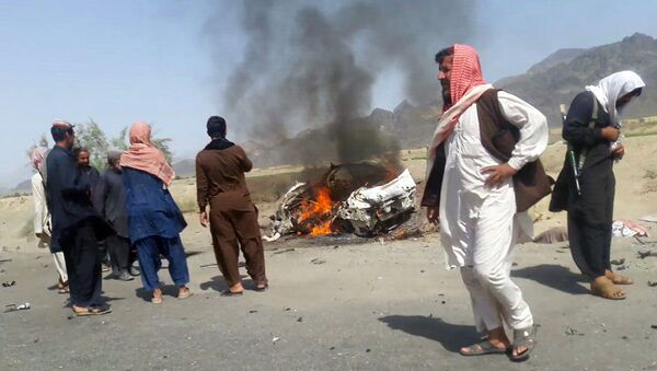 This photograph taken on May 21, 2016 shows Pakistani local residents gathering around a destroyed vehicle hit by a drone strike in which Afghan Taliban Chief Mullah Akhtar Mansour was believed to be travelling in the remote town of Ahmad Wal in Balochistan, around 160 kilometres west of Quetta. - Sputnik International