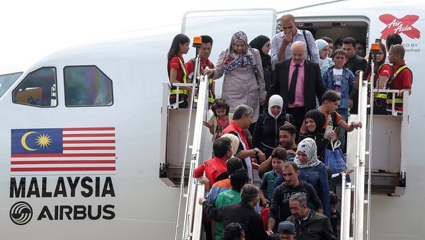 Syrian migrants arrive at Subang Air Force base in Subang, outside Kuala Lumpur on May 28, 2016. - Sputnik International