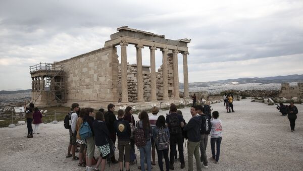 Tourists listen to a guide as they stand in front of the Erechtheion temple during a visit at the Acropolis hill in Athens, on Wednesday, April 15, 2015 - Sputnik International