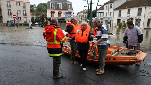 Firefighters evacuate people in a small boat from a flooded street after the Yvette river burst its banks and forced residents to be evacuated in Longjumeau, some 20kms south of Paris, on June 2, 2016 - Sputnik International