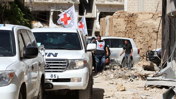 Vehicles of the International Committee of the Red Cross (ICRC) and the United Nations wait on a street after an aid convoy entered the rebel-held Syrian town of Daraya, southwest of the capital Damascus, on June 1, 2016 - Sputnik International