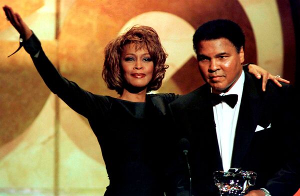Former boxing great Muhammad Ali is given the Courage Award by singer Whitney Houston at the GQ Men of the Year awards show in New York in this October 21, 1998 file photo - Sputnik International