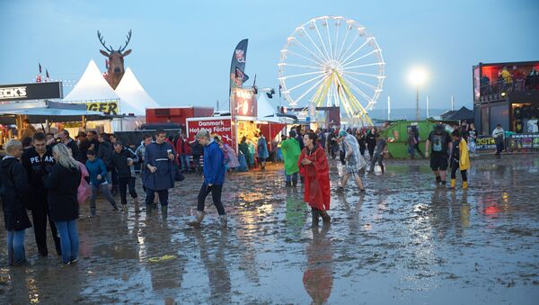 Visitors to the music festival Rock am Ring are seen wading through mud aafter a heavy downpour in the west German city of Mendig on June 3, 2016. - Sputnik International