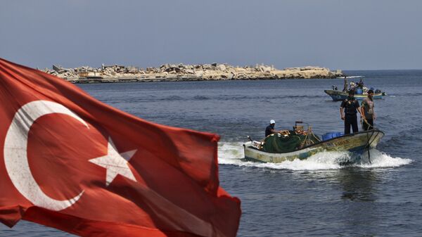 A Turkish flag hangs in the Gaza port as fishermen in their boats pass off the shore of Gaza City, Tuesday, Sept. 13, 2011 - Sputnik International