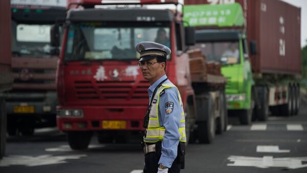 Policeman gestures in front of trucks, China - Sputnik International