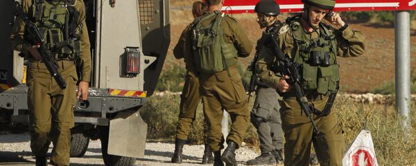 Israeli soldiers are seen at one of the entrances of the Palestinian village of Yatta in the occupied West Bank on June 9,2016 after the army entered the village in search for clues leading to an attack the previous night in the Israeli city of Tel Aviv in which four people were killed and 16 others wounded - Sputnik International
