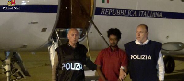 Medhanie Yehdego Mered (C), 35, is pictured with Italian policemen as they land at Palermo airport, Italy, following his arrest in Khartoum, Sudan, on May 24. Medhanie Yehdego Mered (C), 35, is pictured with Italian policemen as they land at Palermo airport, Italy, following his arrest in Khartoum, Sudan, on May 24. - Sputnik International