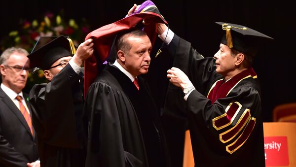 Turkish President Recep Tayyip Erdogan (C) wears an academic hood as he receives an honorary doctorate of laws from Waseda University president Kaoru Kamata (R) at the university in Tokyo on October 8, 2015 - Sputnik International