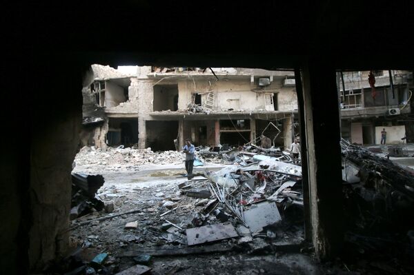 Men inspect damage after an air strike on Aleppo's rebel-held al-Shaar neighbourhood, Syria June 8, 2016 - Sputnik International