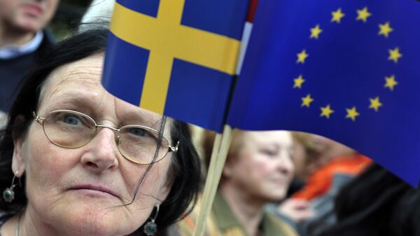 A woman holding a European flag and a Swedish flag - Sputnik International