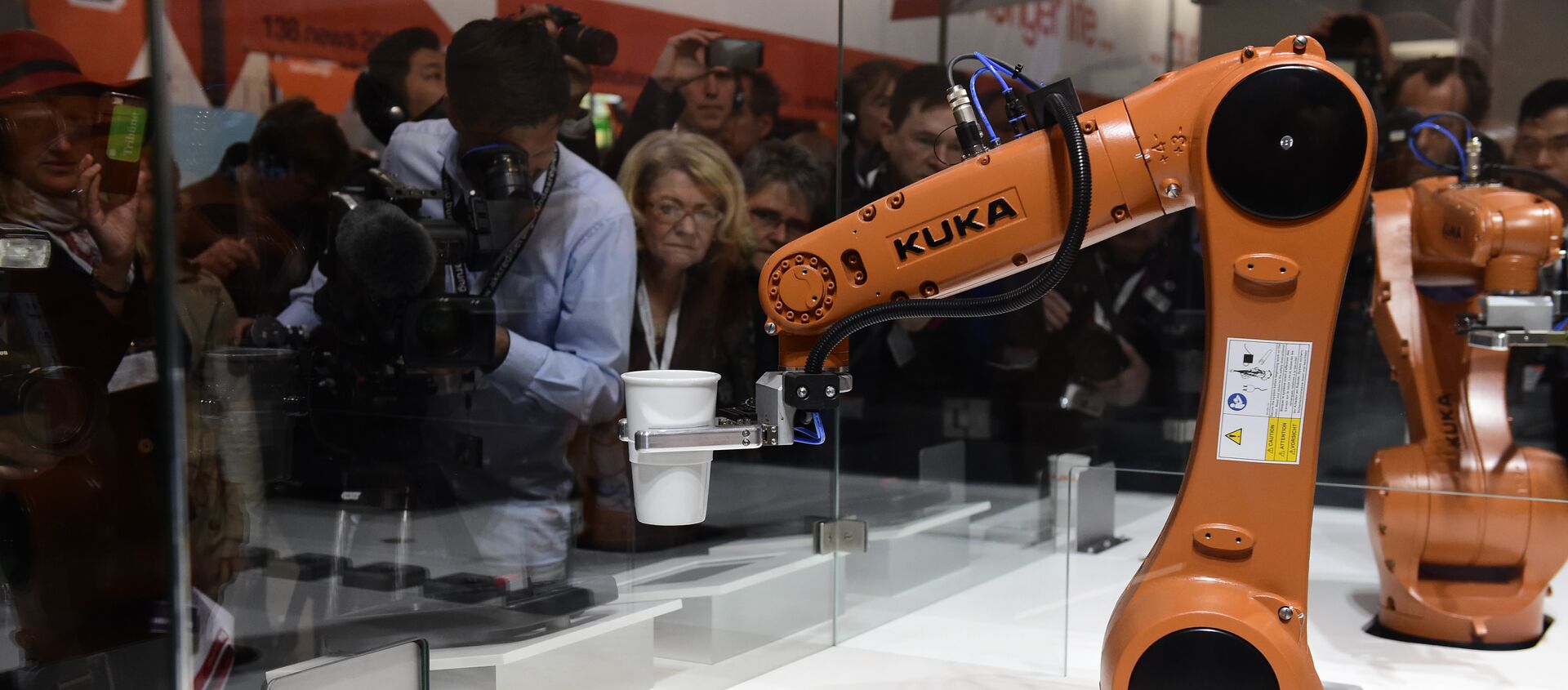 A robot prepares a cup of coffee at the booth of robotics manufacturer KUKA on the eve of the opening of the Hannover Messe (Hanover fair) in Hanover, northern Germany, on April 23, 2016 - Sputnik International, 1920, 23.12.2020