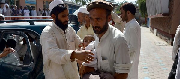 An Afghan volunteer carries a wounded child following an explosion inside a mosque in the Rodat district of Nangarhar province on June 10, 2016 An Afghan volunteer carries a wounded child following an explosion inside a mosque in the Rodat district of Nangarhar province on June 10, 2016 - Sputnik International