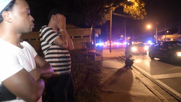 Jermaine Towns, left, and Brandon Shuford wait down the street from a multiple shooting at a nightclub in Orlando, Fla., Sunday, June 12, 2016 - Sputnik International