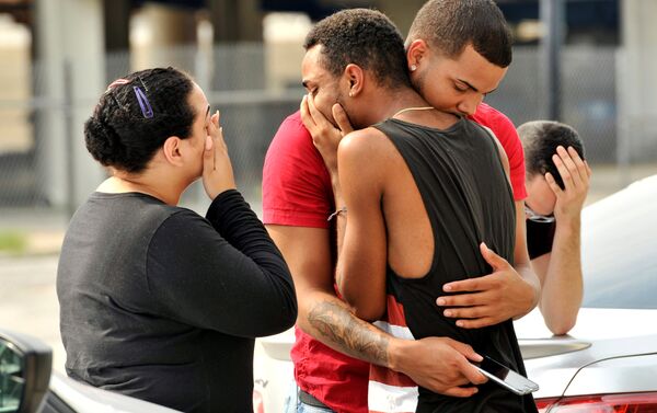 Friends and family members embrace outside the Orlando Police Headquarters during the investigation of a shooting at the Pulse night club, where as many as 20 people have been injured after a gunman opened fire, in Orlando, Florida, U.S June 12, 2016 - Sputnik International