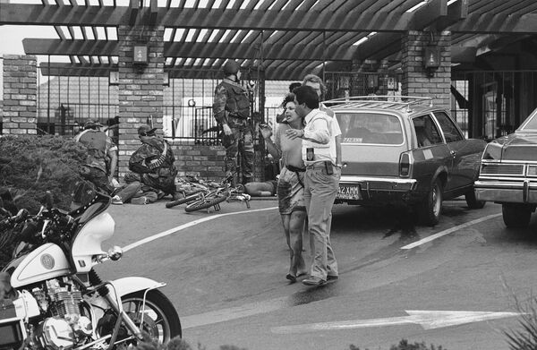 A bloodied victim is led away by police as SWAT officers assist the wounded at a McDonald's restaurant, July 18, 1984 in San Ysidro, California A bloodied victim is led away by police as SWAT officers assist the wounded at a McDonald's restaurant, July 18, 1984 in San Ysidro, California - Sputnik International