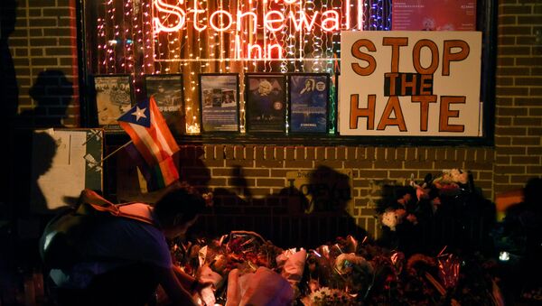 Shadows are cast on a wall as a man lights a candle at a memorial outside The Stonewall Inn on Christopher Street, considered by some as the center of New York State's gay rights movement, following the shooting massacre at Orlando's Pulse nightclub, in the Manhattan borough of New York, U.S., June 12, 2016. - Sputnik International