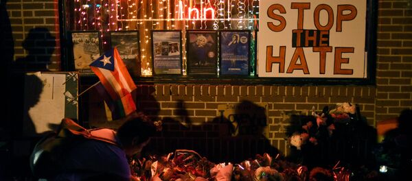 Shadows are cast on a wall as a man lights a candle at a memorial outside The Stonewall Inn on Christopher Street, considered by some as the center of New York State's gay rights movement, following the shooting massacre at Orlando's Pulse nightclub, in the Manhattan borough of New York, U.S., June 12, 2016. - Sputnik International