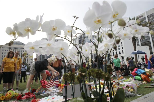 A visitor plants an American flag at a vigil for the shooting victims of Orlando's Pulse nightclub in Orlando, Florida, United States June 13, 2016 A visitor plants an American flag at a vigil for the shooting victims of Orlando's Pulse nightclub in Orlando, Florida, United States June 13, 2016 - Sputnik International