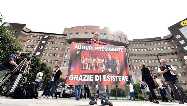 A man holds a banner reading All the best president, thanks for existing in front of San Raffaele hospital, as Italian surgeons begin a four-hour heart operation on former prime minister Silvio Berlusconi on Tuesday to replace a defective aortic valve, a hospital statement said, in Milan, Italy June 14, 2016. - Sputnik International