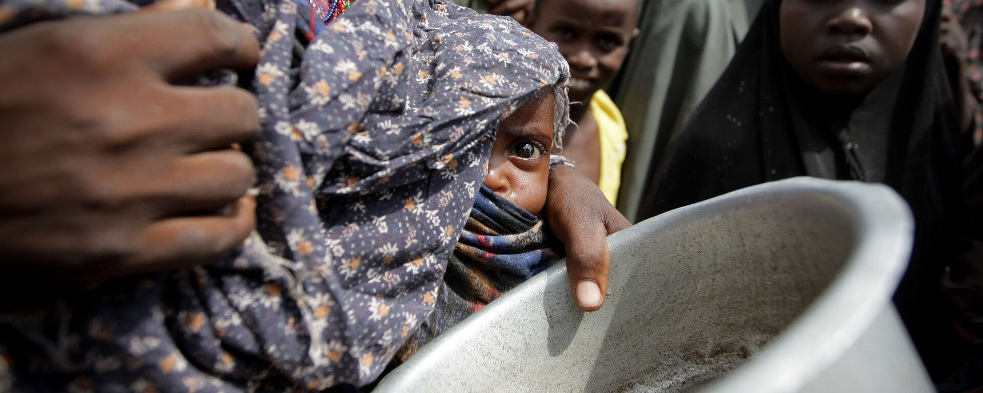 A woman holding her young malnourished baby queues for food at the Badbado camp for Internally Displaced Persons (IDPs). Famine has been declared in two regions of southern Somalia – southern Bakool and Lower Shabelle. - Sputnik International, 1920, 06.04.2022